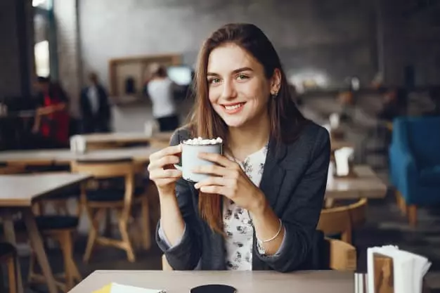 Lány ül egy kávézóban