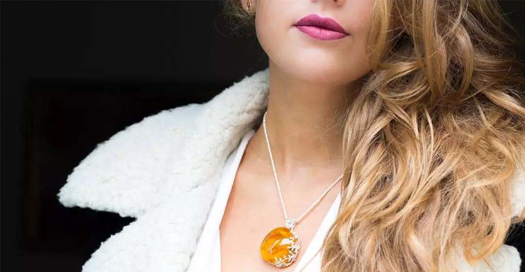 Liontin dengan amber di leher foto gadis
