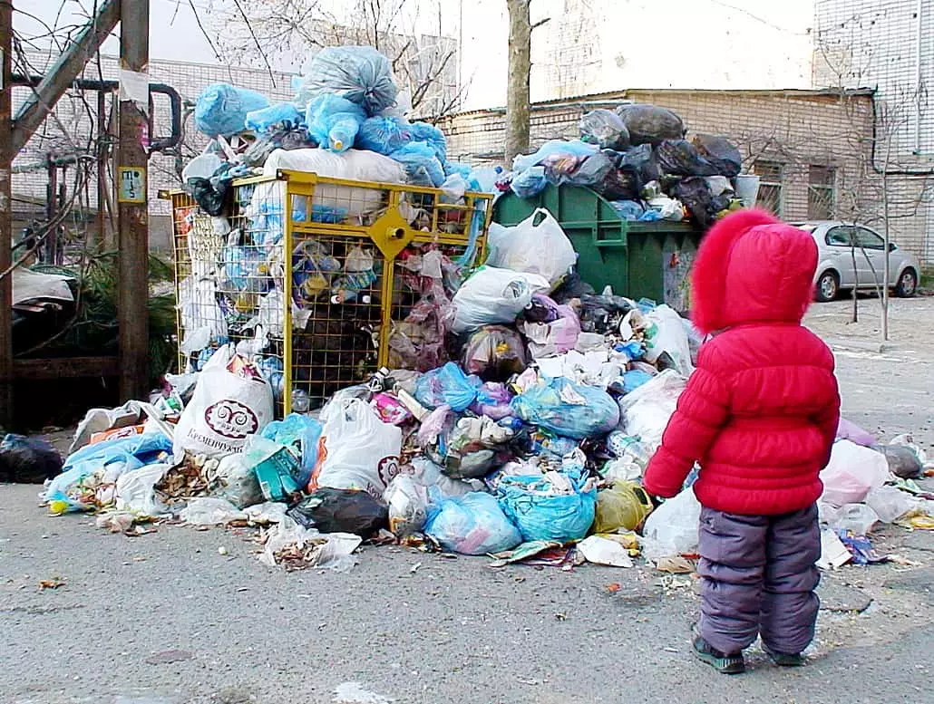 Bērns skatās uz atkritumiem