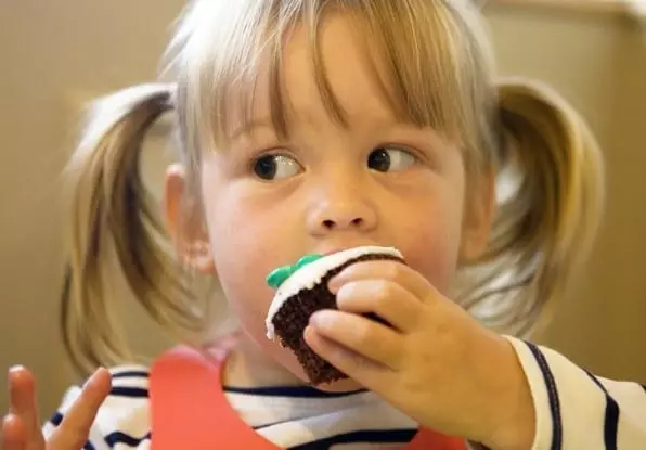 Το παιδί τρώει ένα κέικ